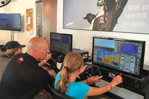 Instructor and student using flight simulator technology on computers