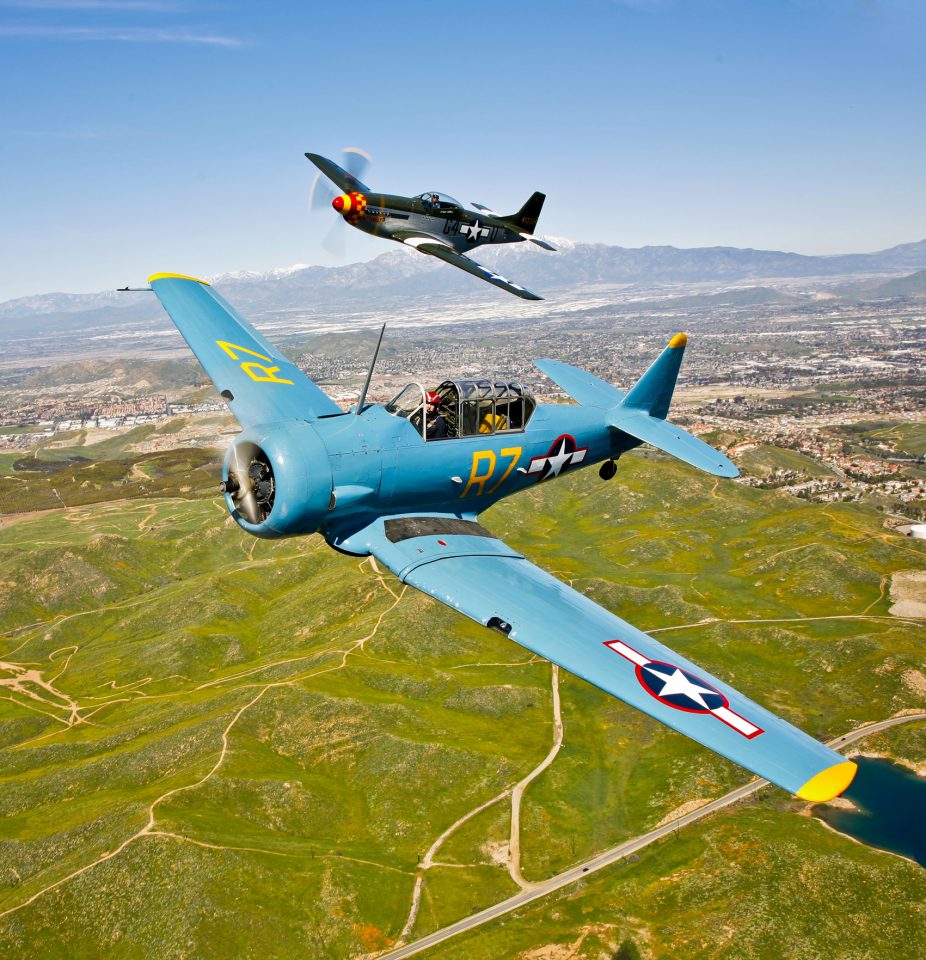 A North American T-6 Texan and a P-51D Mustang in flight over Chino, California.