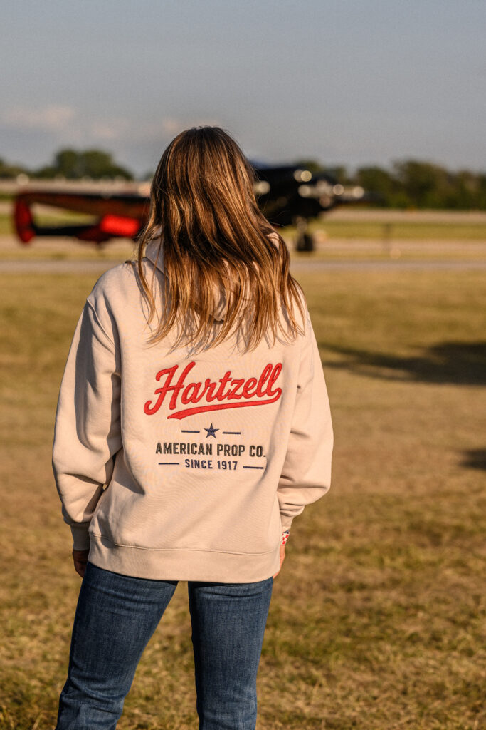 Woman wearing Hartzell Hoodie at Oshkosh 2026