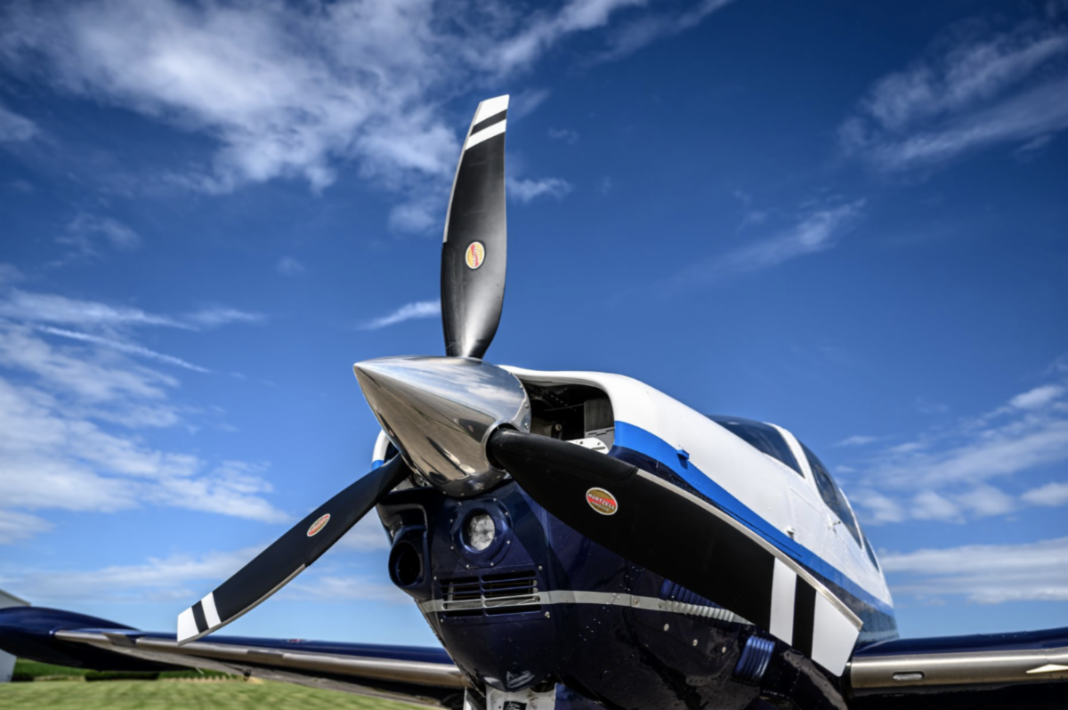 Alt text: A close-up front low shot of a single engine airplane with a three-blade Hartzell Propeller.
