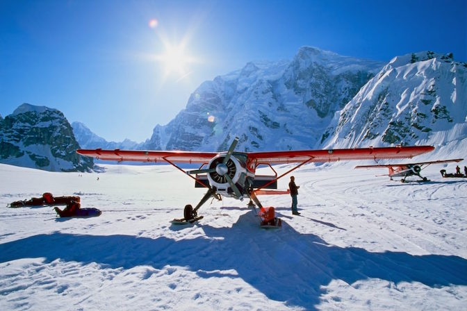 Propeller-driven airplane in a snowy mountainous area.